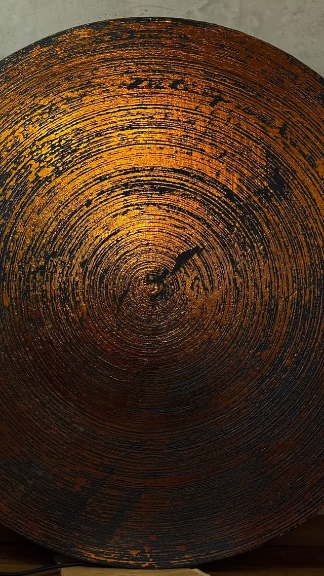 Bronze circle radiant panel catching warm light